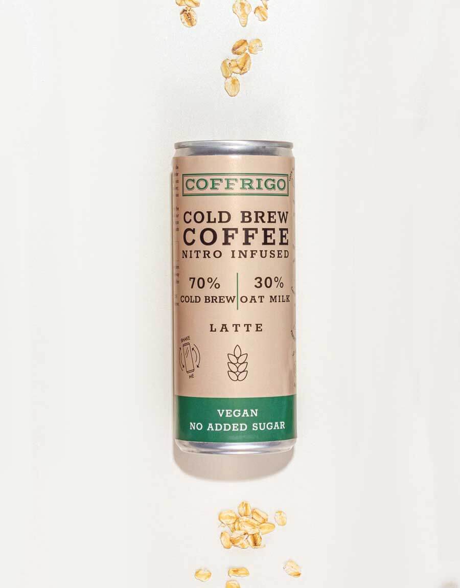 Dose Cold Brew Kaffee OAT MILK LATTE liegend von oben fotografiert mit Haferflocken oben und unten dekoriert